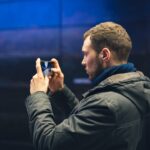 Hombre joven tomando fotos con su smartphone para crear contenido.