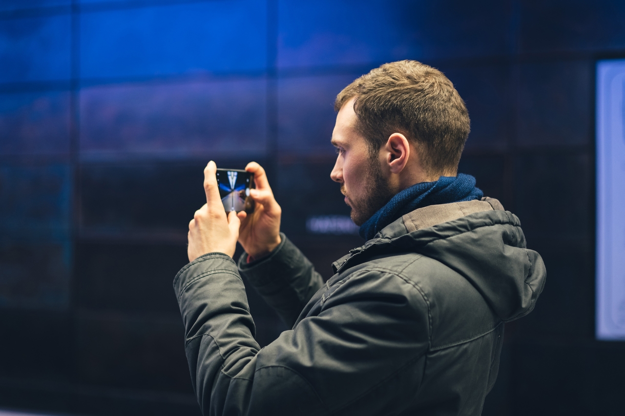 Hombre joven tomando fotos con su smartphone para crear contenido.